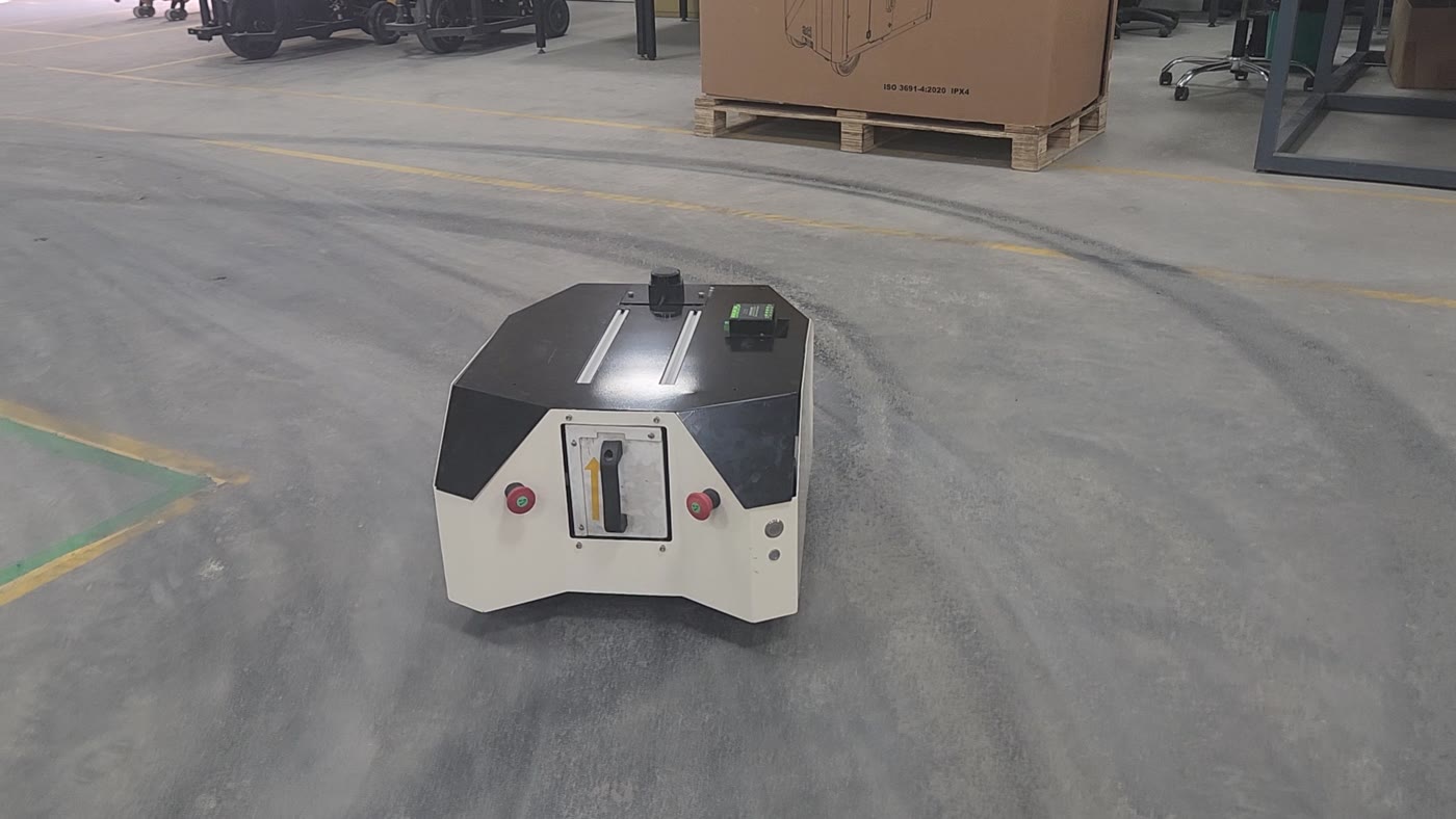 An Ati autonomous mobile robot driving along a marked lane on a factory floor, past pallet trucks and shelving.