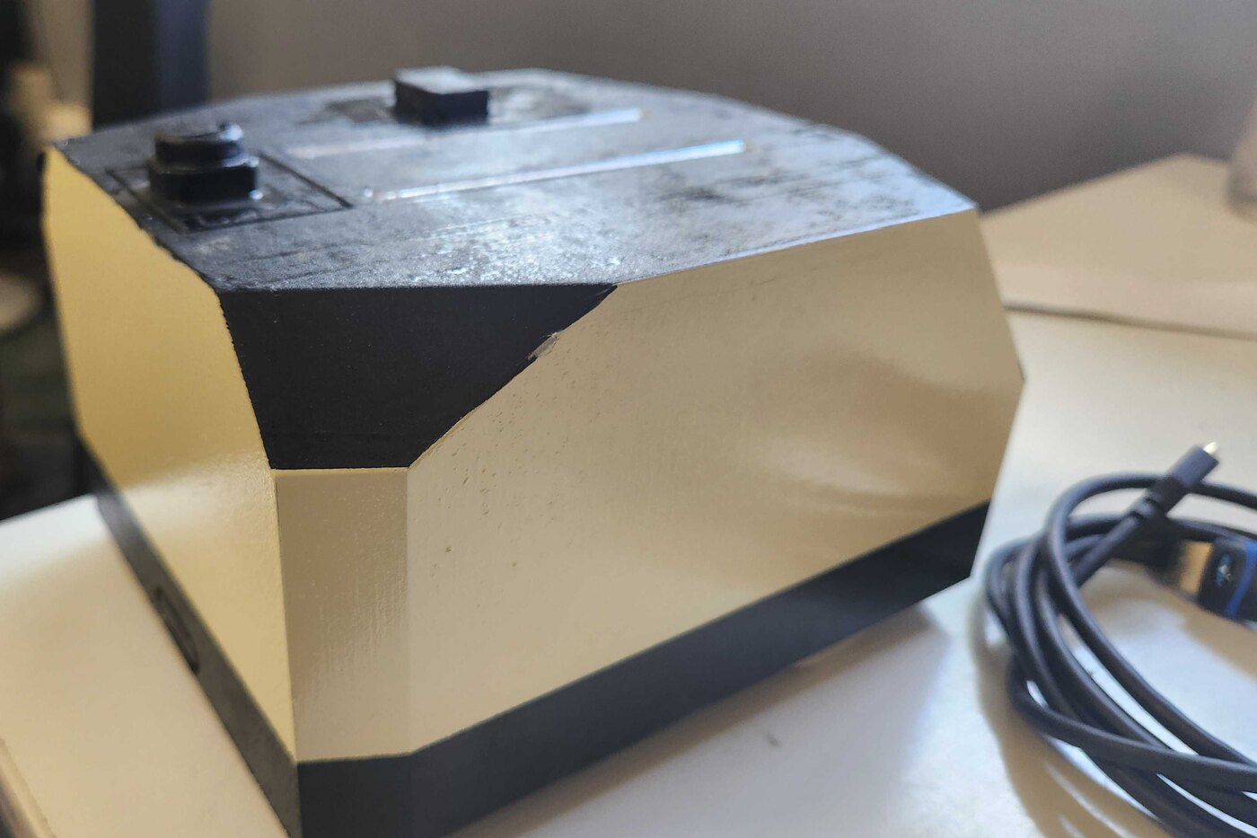 The light-duty AMR on a bench: a faceted chassis in cream and black with sensor cutouts on the top deck.