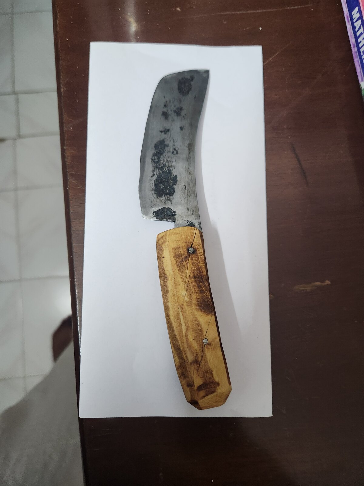 Three forged blade blanks laid on a white sheet, edges partly ground bright, the rest still dark with forge scale.